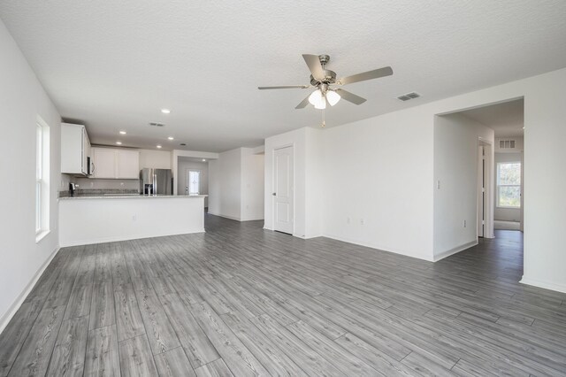 unfurnished living room featuring light hardwood / wood-style floors, a textured ceiling, and ceiling fan