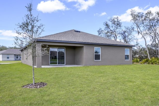 back of property featuring stucco siding, roof with shingles, a patio area, and a yard