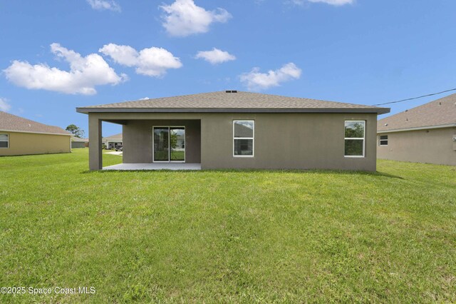 539 Hamwood St SW, Palm Bay, FL 32908 - back of property featuring stucco siding, a patio, a lawn, and roof with shingles