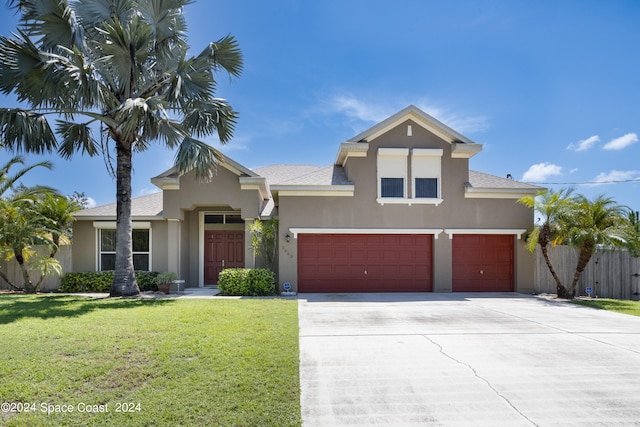 view of front of house with a garage and a front lawn