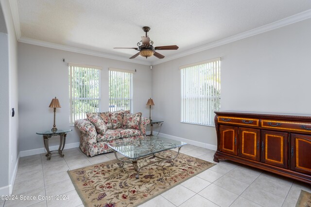 tiled living room with ceiling fan, crown molding, and a healthy amount of sunlight