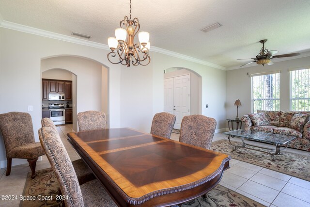 tiled dining area featuring ceiling fan with notable chandelier, crown molding, and a textured ceiling