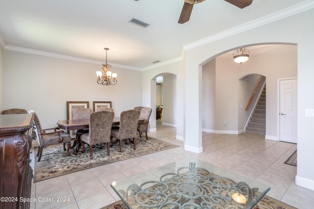 dining room featuring ceiling fan with notable chandelier, ornamental molding, and light tile patterned floors