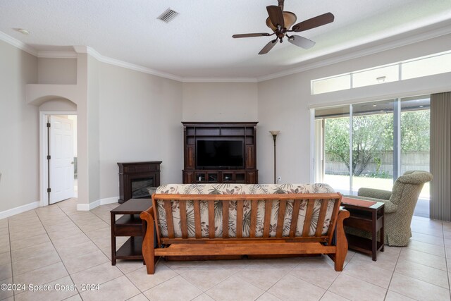 tiled living room featuring ornamental molding, a textured ceiling, and ceiling fan