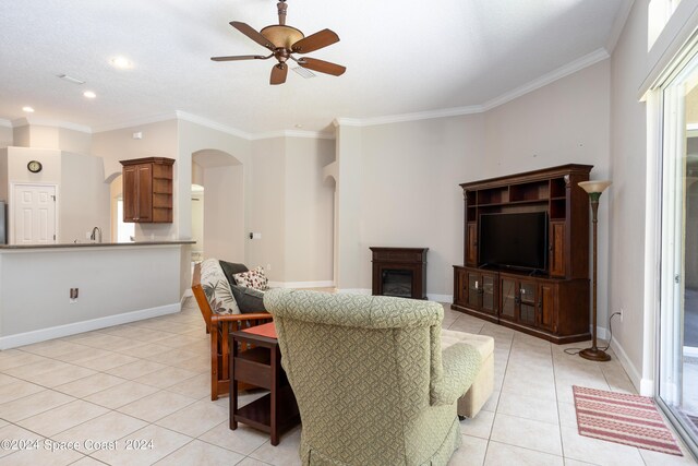 living room featuring crown molding, ceiling fan, and light tile patterned floors