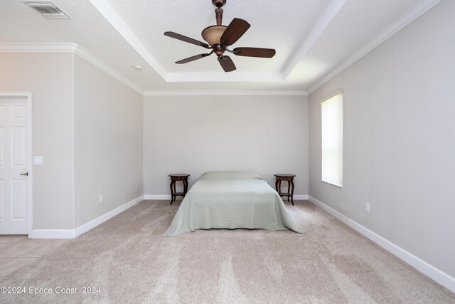 bedroom with a tray ceiling, light colored carpet, ceiling fan, and a textured ceiling