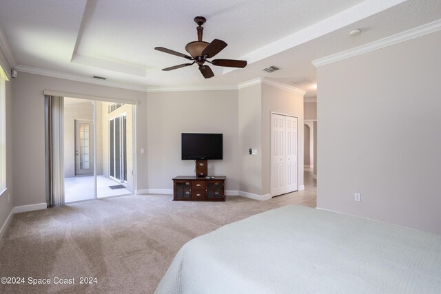 carpeted bedroom with crown molding, a closet, a tray ceiling, access to outside, and ceiling fan