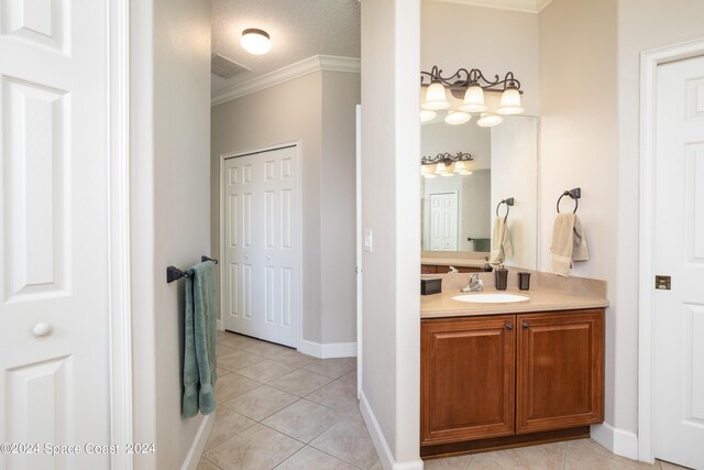 bathroom with tile patterned floors, crown molding, a textured ceiling, and vanity