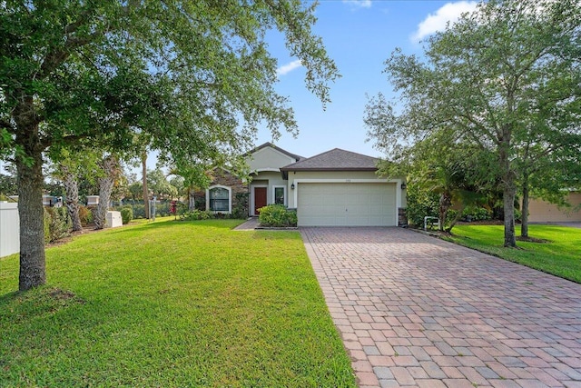 view of front facade with fence, a front yard, stucco siding, decorative driveway, and an attached garage