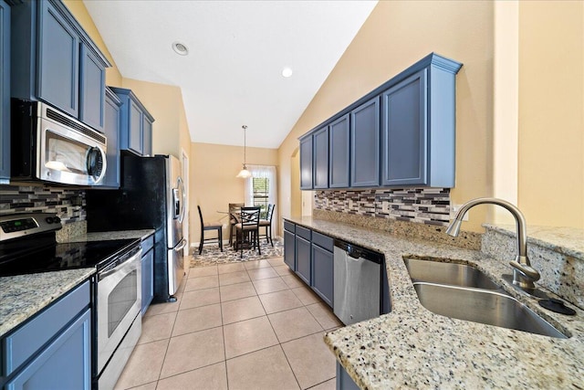 kitchen featuring vaulted ceiling, light stone counters, appliances with stainless steel finishes, light tile patterned flooring, and a sink