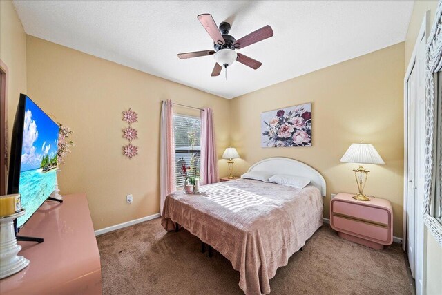 carpeted bedroom featuring a ceiling fan and baseboards