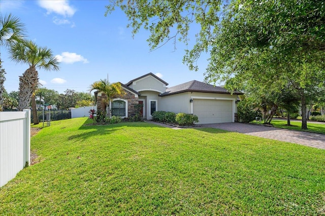 ranch-style house with stucco siding, decorative driveway, fence, a front yard, and an attached garage