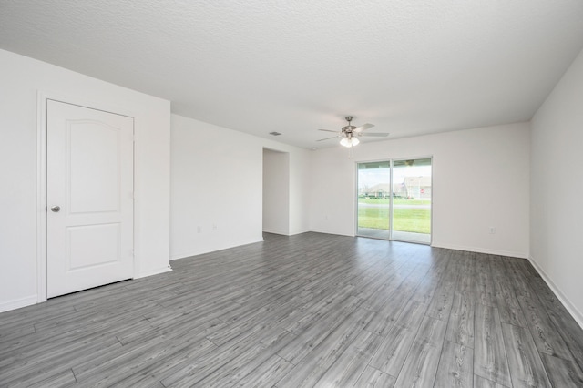 empty room with a textured ceiling, light wood-type flooring, and ceiling fan