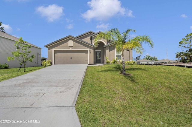 2270 Harbison Ave SW, Palm Bay, FL 32908 - view of front of home with a garage, driveway, stucco siding, and a front lawn
