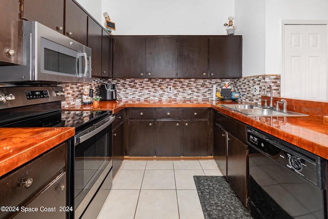 kitchen featuring stainless steel appliances, dark brown cabinetry, light tile patterned floors, and tasteful backsplash