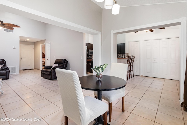 dining space with high vaulted ceiling, light tile patterned flooring, visible vents, and a ceiling fan