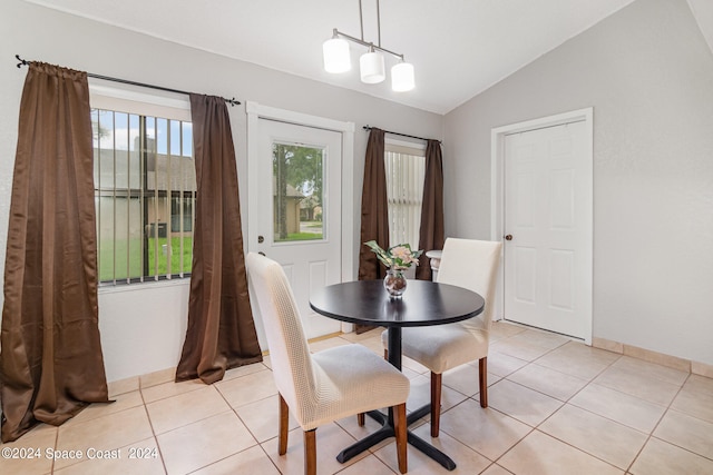 dining area with lofted ceiling and light tile patterned floors