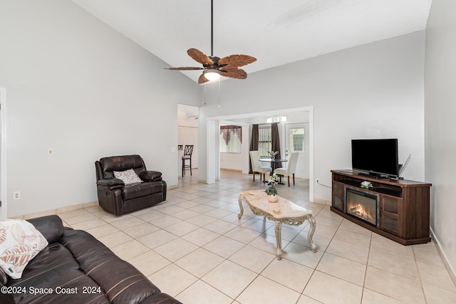 living area featuring light tile patterned floors, high vaulted ceiling, a ceiling fan, and a glass covered fireplace