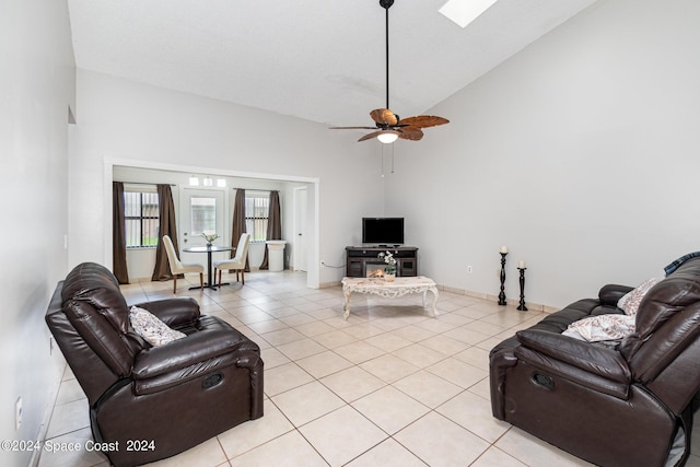 living area with high vaulted ceiling, a ceiling fan, baseboards, and light tile patterned floors