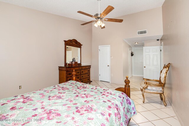 bedroom featuring a textured ceiling, high vaulted ceiling, light tile patterned flooring, and ceiling fan