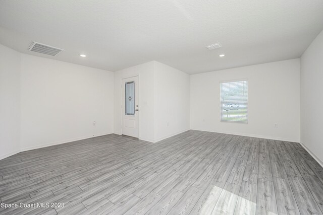 unfurnished room featuring wood finished floors, baseboards, and recessed lighting