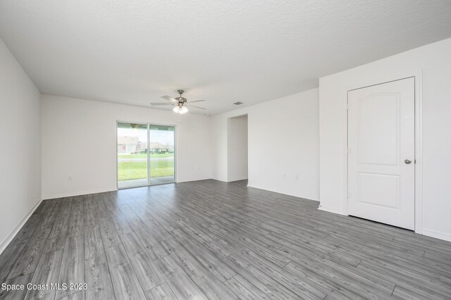 unfurnished room featuring a ceiling fan, wood finished floors, and baseboards