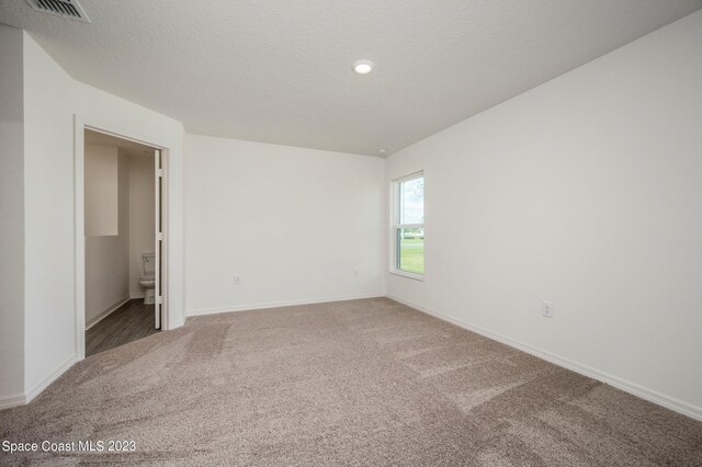 unfurnished bedroom featuring carpet, baseboards, recessed lighting, a textured ceiling, and ensuite bathroom