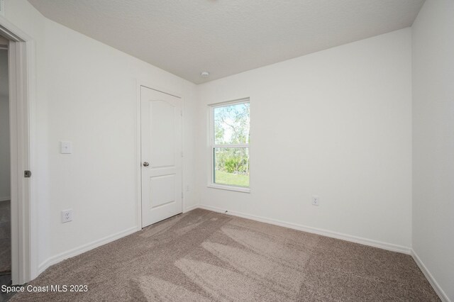 spare room with carpet and baseboards