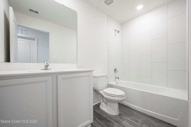 bathroom with toilet, vanity, wood finished floors, bathing tub / shower combination, and recessed lighting