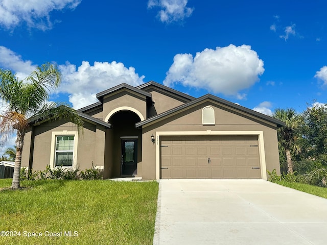 ranch-style house featuring driveway, a front lawn, an attached garage, and stucco siding