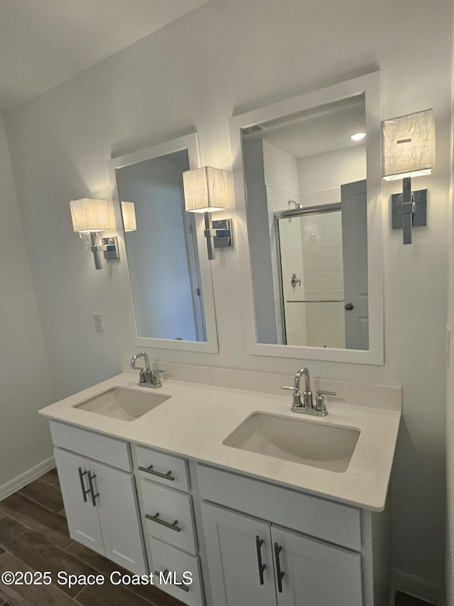 bathroom featuring a shower with door and vanity