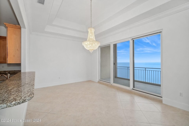 unfurnished dining area featuring light tile patterned floors, a tray ceiling, and baseboards