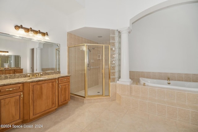 bathroom with a bath, tile patterned flooring, a shower stall, and decorative columns