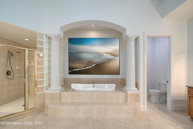 bathroom featuring toilet, a bath, a shower stall, and ornate columns