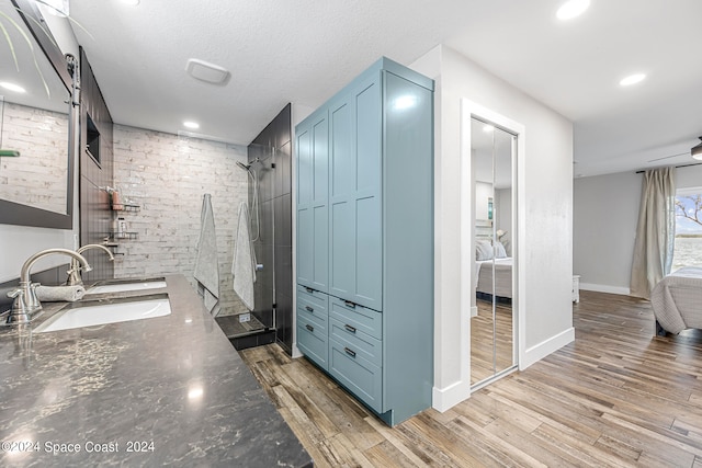 interior space featuring light wood-type flooring, a barn door, a textured ceiling, and sink