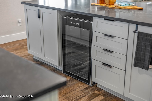 details featuring beverage cooler, dark hardwood / wood-style flooring, and white cabinets