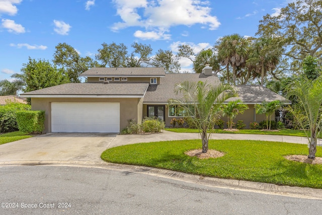 view of front of property featuring a garage and a front lawn