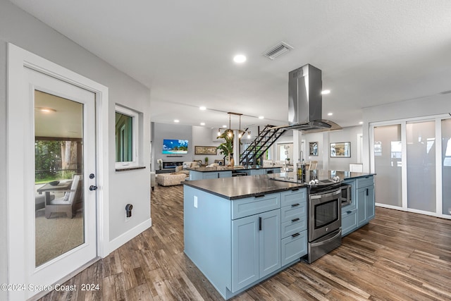 kitchen featuring a kitchen island, dark wood-type flooring, blue cabinets, island exhaust hood, and appliances with stainless steel finishes