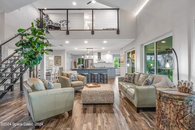 living room with a high ceiling, a wealth of natural light, and dark hardwood / wood-style floors