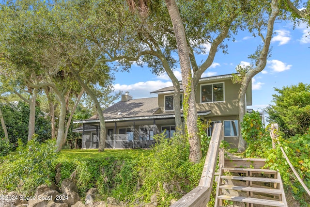 back of property with a sunroom