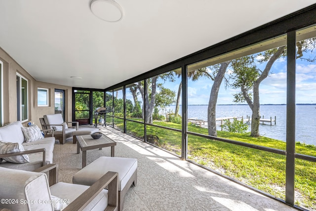 sunroom featuring a water view