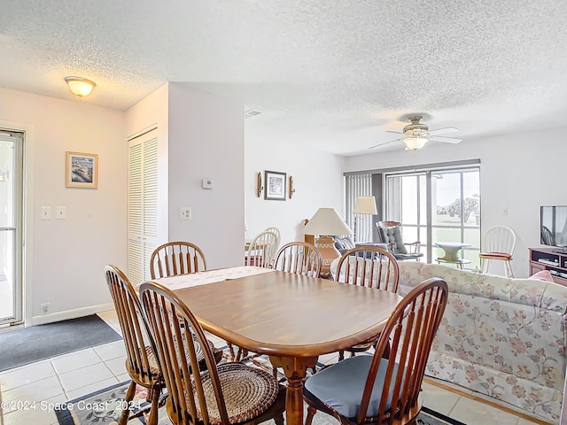 dining area with a textured ceiling, ceiling fan, and light tile patterned floors