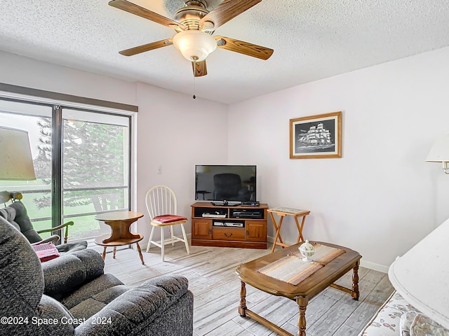 living room with a textured ceiling, light hardwood / wood-style flooring, and ceiling fan