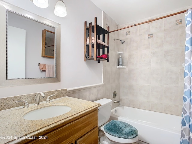 full bathroom with tile walls, toilet, shower / tub combo with curtain, and vanity