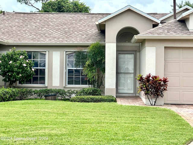 property entrance with a yard and a garage