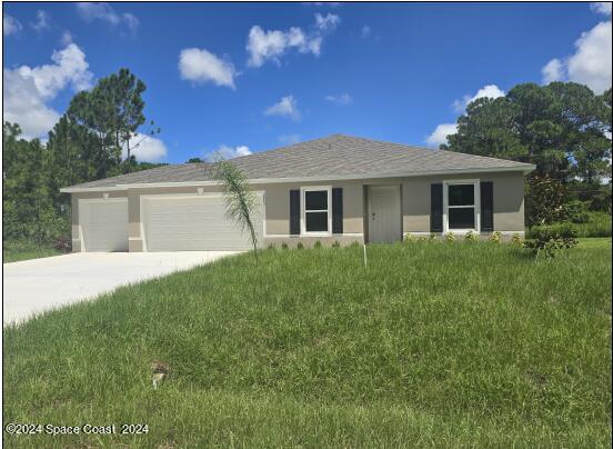 view of front of home featuring a garage and a front lawn