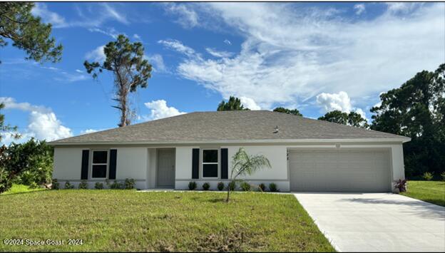 ranch-style home featuring a garage and a front yard