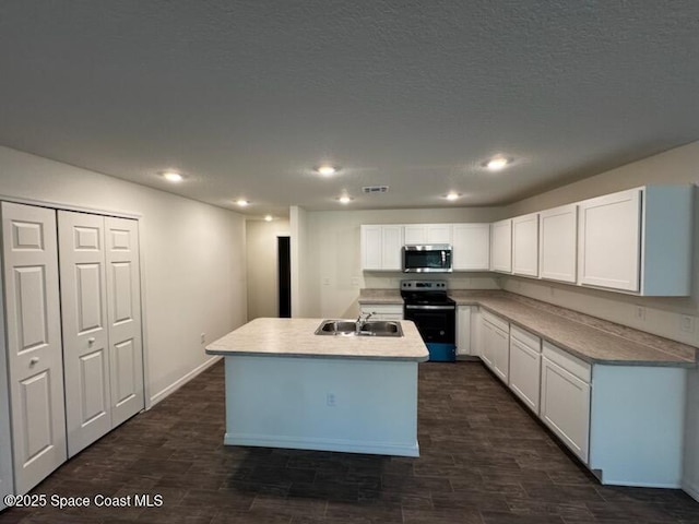 kitchen with sink, a textured ceiling, an island with sink, white cabinetry, and stainless steel appliances