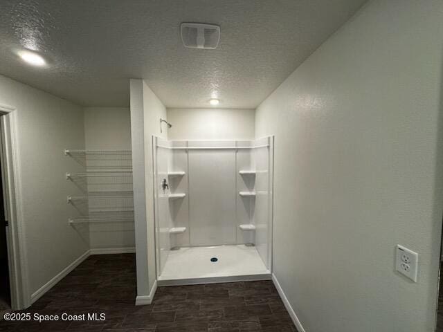 bathroom with a textured ceiling and walk in shower