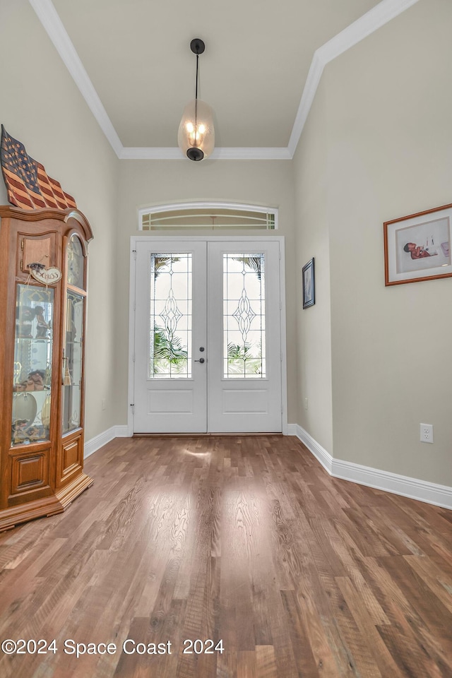 foyer entrance featuring baseboards, french doors, wood finished floors, and crown molding